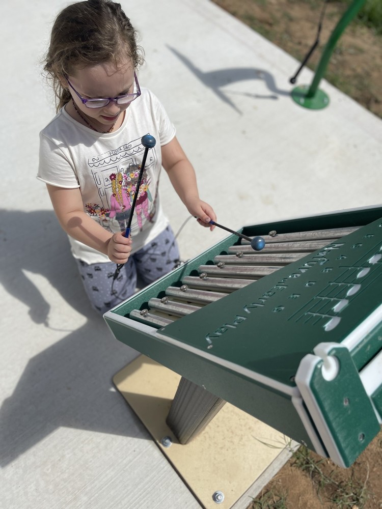 1st grade student play outdoor musical instrument.