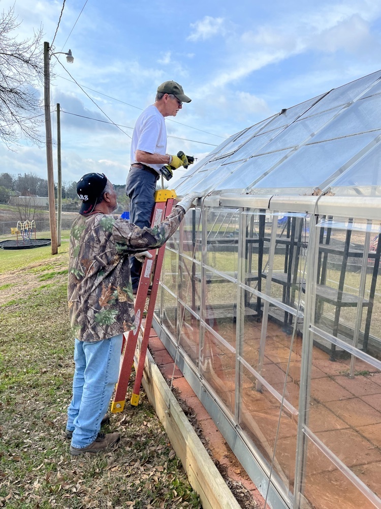 men fixing a greenhouse